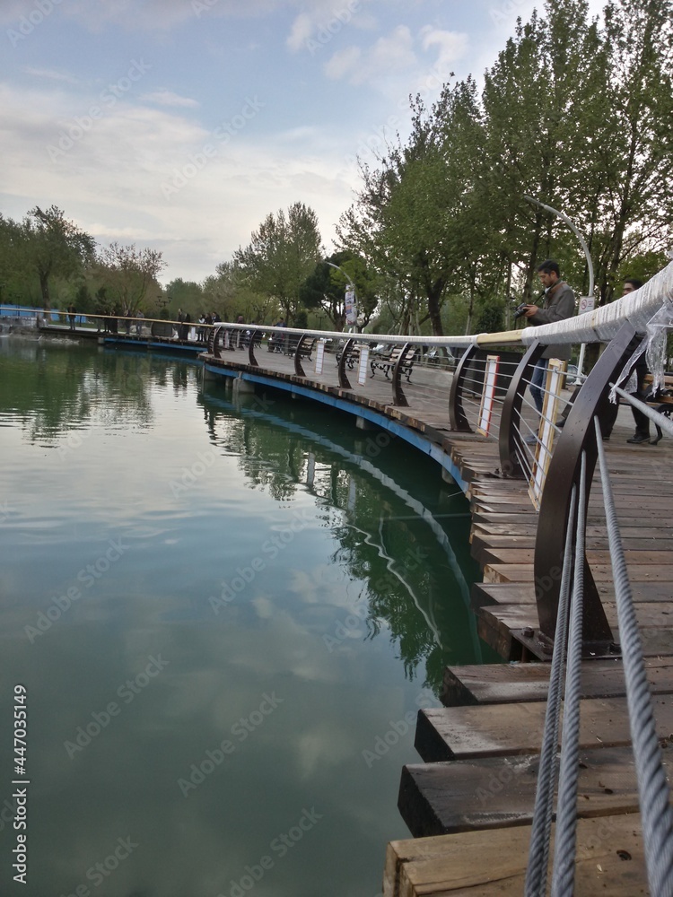 a lake in park with wooden bridge a lake in park with wooden bridge