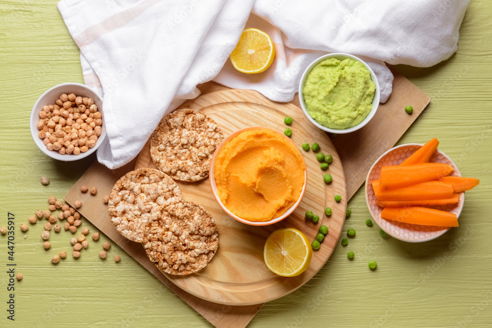 Composition with tasty hummus, lemon and chickpeas on color wooden background Composition with tasty hummus, lemon and chickpeas on color wooden background