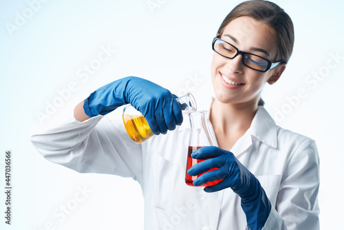 Woman in white coat laboratory assistant chemical solution research analyzes