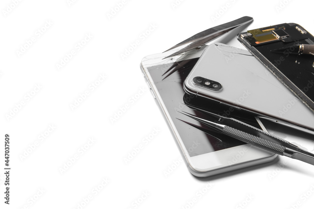 Damaged mobile phones with technician tools on white background Damaged mobile phones with technician tools on white background