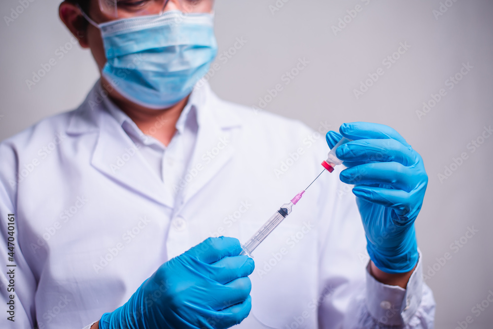 Doctor holding tube with Coronavirus vaccine and syringe. Healthcare And Medical concept. Doctor holding tube with Coronavirus vaccine and syringe. Healthcare And Medical concept.