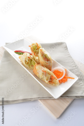deep fried vegetable spring roll in long plate in white background dim sum snack Halal menu