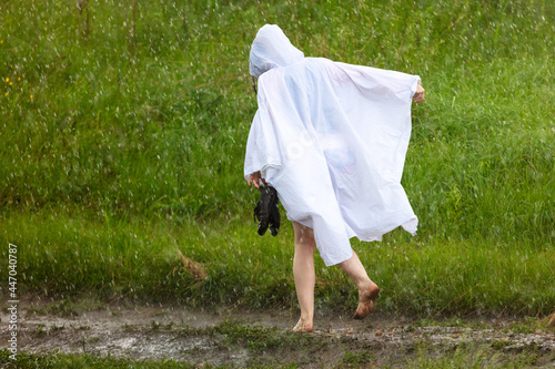 A girl in a white raincoat in the rain