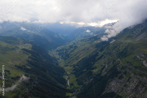 Tolle Drohneaufnahmen in den schweizer Alpen. Wundervolle grüne Bäume und ein mächtiger Wasserfall in mitten des Waldes. Vogelperspektive.
