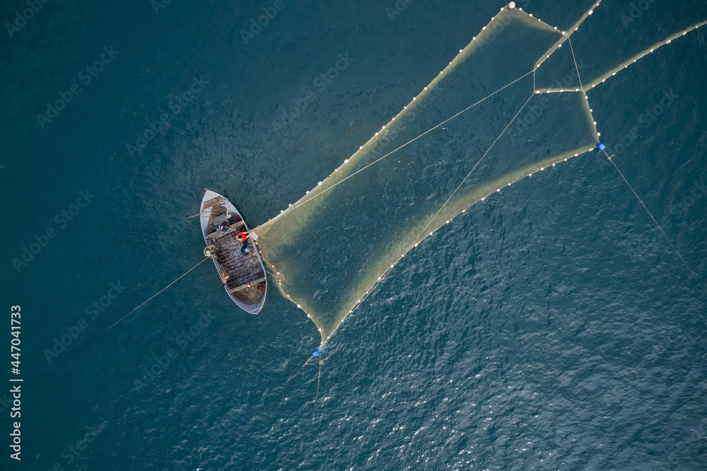 Φωτογραφία A boat with a net in the middle of the ocean.