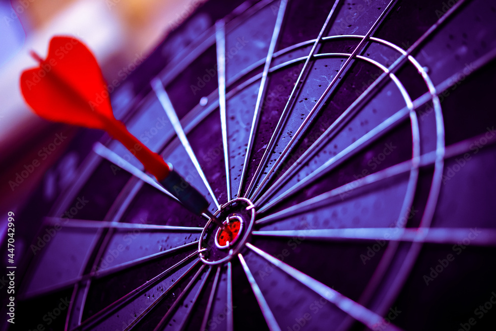 Φωτογραφία Close up shot of the dart arrow hit on bulleyes of dartboard to represent that the business reached the target of company with dark tone picture style