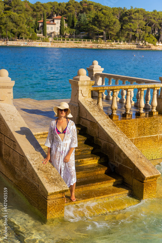 Girl in a white dress on a beach in Mali Lošinj, Croatia photo