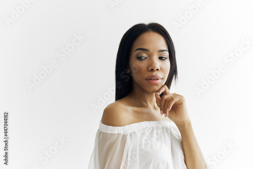 woman african appearance in white dress posing cosmetics luxury light background