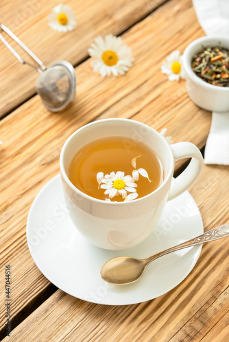 Cup with tasty floral tea on wooden background