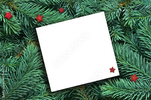 Background of many green Christmas tree branches and paper for text.