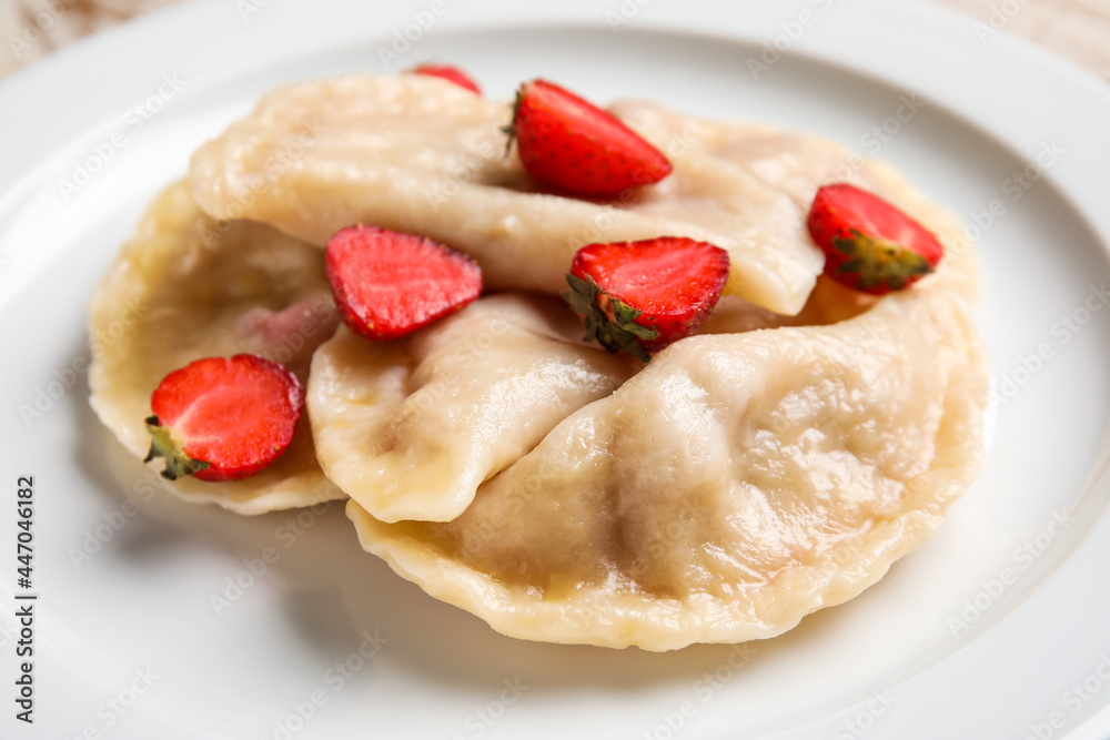 Tasty dumplings and strawberry on plate, closeup Tasty dumplings and strawberry on plate, closeup