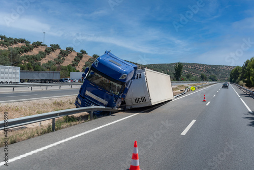 Truck with an accident refrigerated semi-trailer, overturned by the exit of the highway in the median of the highway.