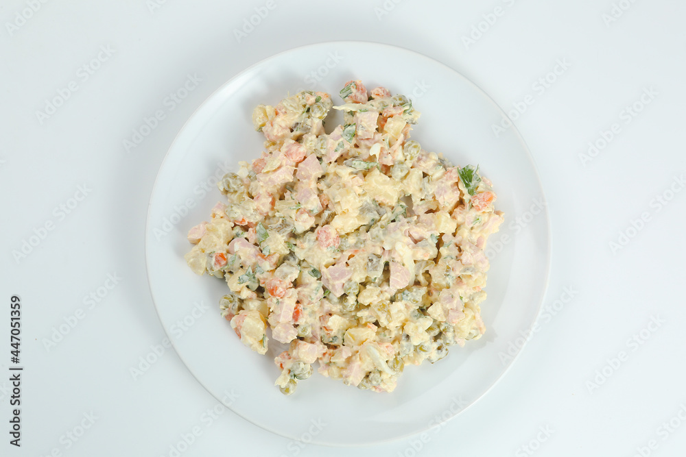 Traditional russian salad Olivier from boiled vegetables and meat with sauce in bowl. Russian New Year or Christmas isolated on white Traditional russian salad Olivier from boiled vegetables and meat with sauce in bowl. Russian New Year or Christmas isolated on white