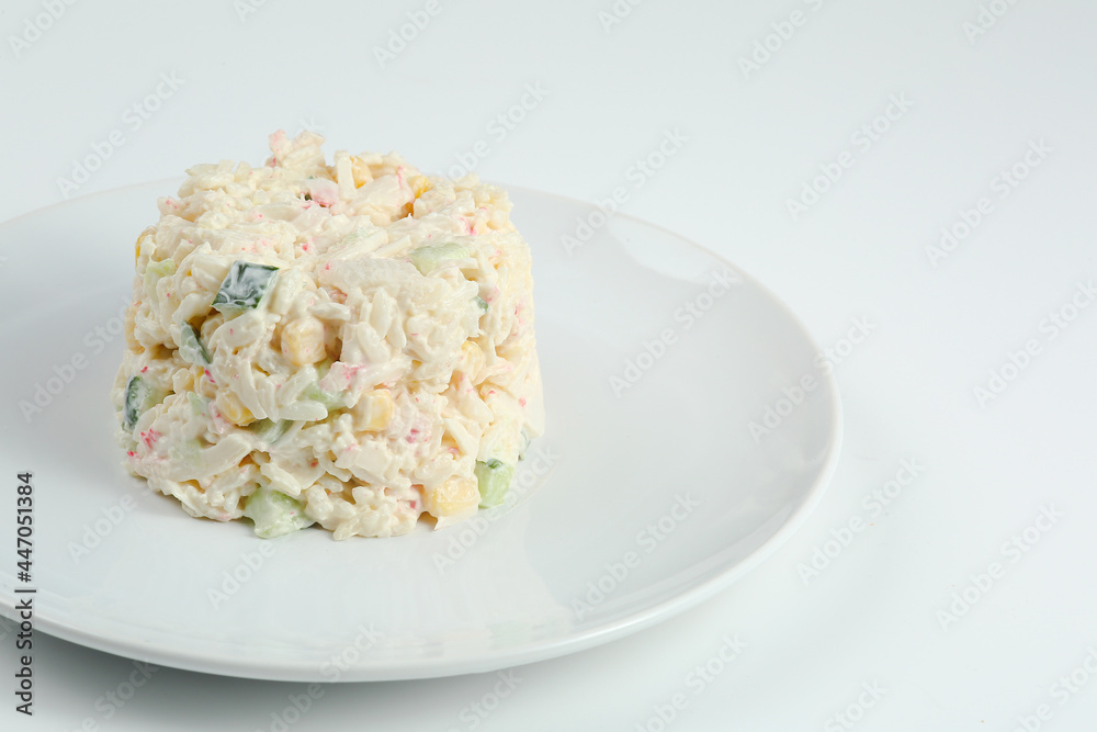 crab salad with rice on white plate closeup with copy space. Russian traditional salad with crab sticks isolated on white crab salad with rice on white plate closeup with copy space. Russian traditional salad with crab sticks isolated on white