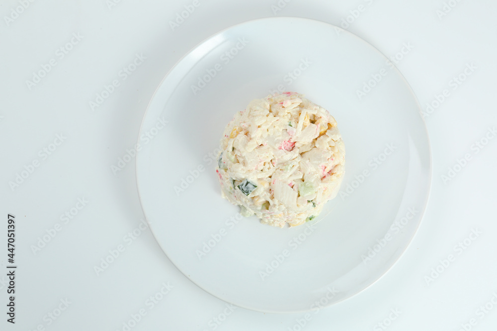 crab salad with rice on white plate closeup with copy space. Russian traditional salad with crab sticks isolated on white crab salad with rice on white plate closeup with copy space. Russian traditional salad with crab sticks isolated on white