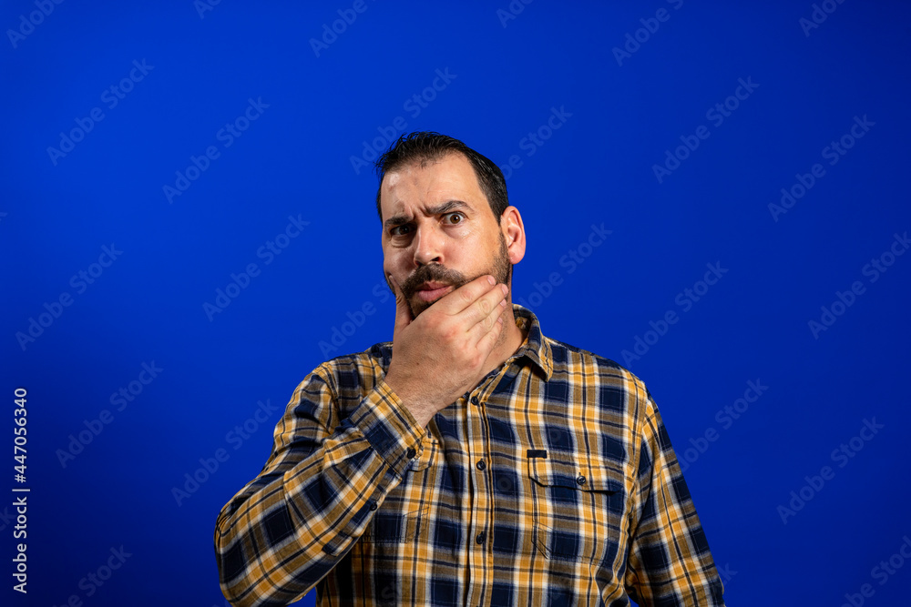 Handsome middle age senior man with grey hair over isolated blue background with hand on chin thinking about question, pensive expression. Smiling and thoughtful face. Doubt concept. Handsome middle age senior man with grey hair over isolated blue background with hand on chin thinking about question, pensive expression. Smiling and thoughtful face. Doubt concept.