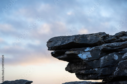 Fototapeta rocky stone consisting of several layers against the background of the sky