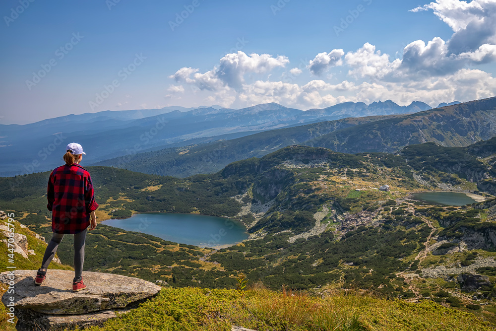 A young girl enjoys a beautiful view from top .Travel in the mountains.