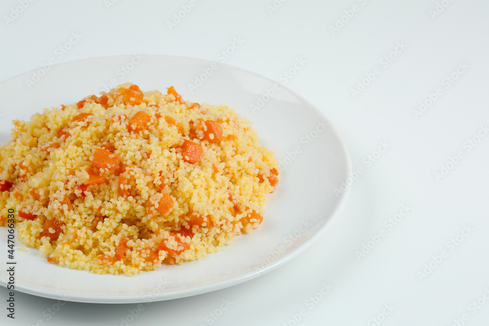 couscous with carrots in white plate closeup. couccous isolated on white background
