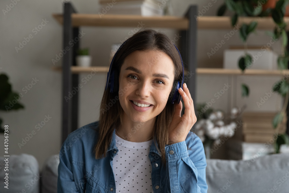 Profile picture attractive woman sit on couch look at camera listens to friend through wireless headphones. Applicant participate in job interview remotely by video call. Virtual meeting event concept Profile picture attractive woman sit on couch look at camera listens to friend through wireless headphones. Applicant participate in job interview remotely by video call. Virtual meeting event concept