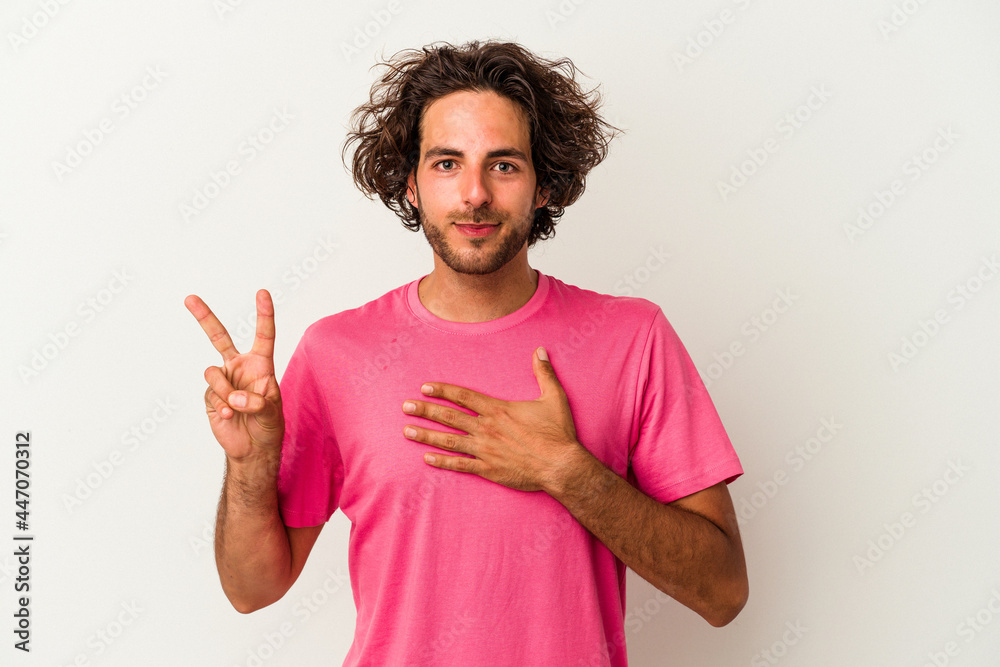 Young caucasian man isolated on white background taking an oath, putting hand on chest.