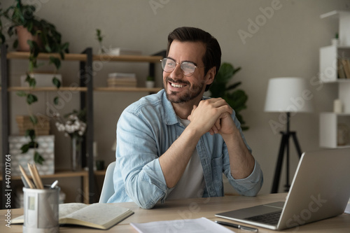 Tableau sur toile Smiling successful handsome man entrepreneur in glasses sit at desk looks into d