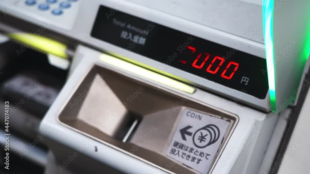 Closeup passenger hand adding Japanese's coin into ticket vending machine at platform station, metro daily ticket pass, tourism fee, technology self buying ticket, modern mass rapid transit system Closeup passenger hand adding Japanese's coin into ticket vending machine at platform station, metro daily ticket pass, tourism fee, technology self buying ticket, modern mass rapid transit system