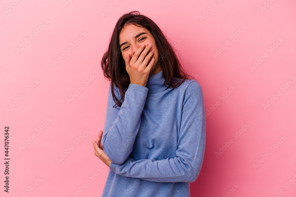 Young caucasian woman isolated on pink background laughing happy, carefree, natural emotion.