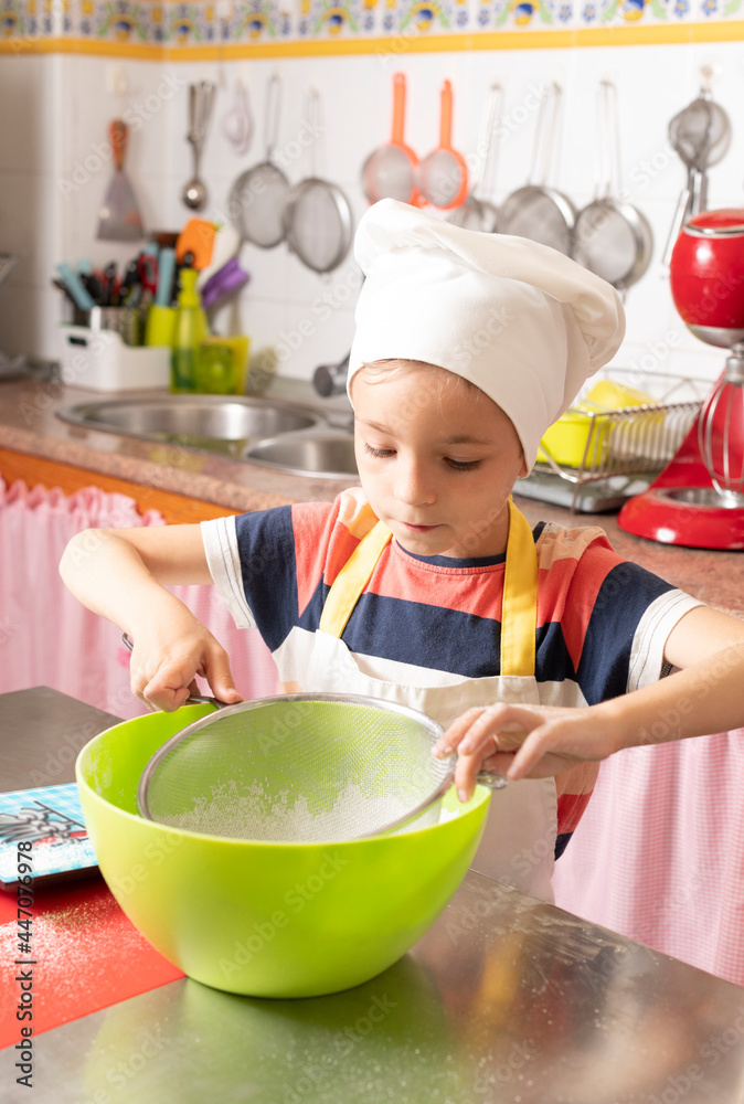 child baker in the kitchen prepares cake child baker in the kitchen prepares cake