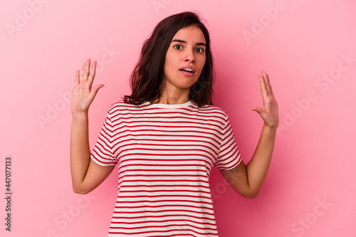 Young caucasian woman isolated on pink background being shocked due to an imminent danger