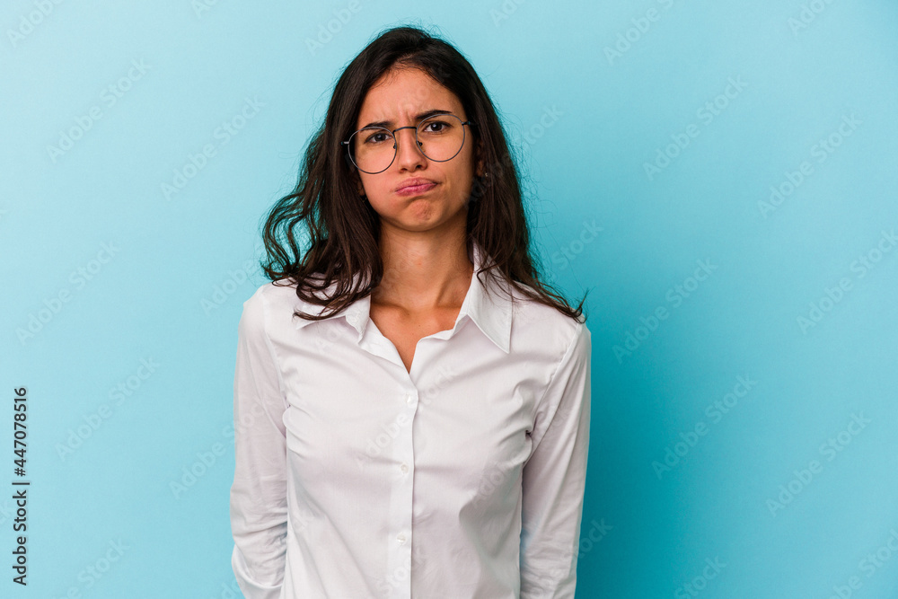 Young caucasian woman isolated on blue background blows cheeks, has tired expression. Facial expression concept. Young caucasian woman isolated on blue background blows cheeks, has tired expression. Facial expression concept.