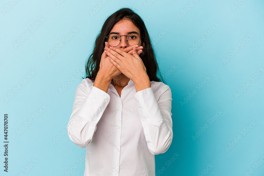 Young caucasian woman isolated on blue background covering mouth with hands looking worried. Young caucasian woman isolated on blue background covering mouth with hands looking worried.