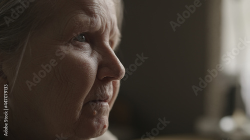 Senior woman sitting indoor with soft window light