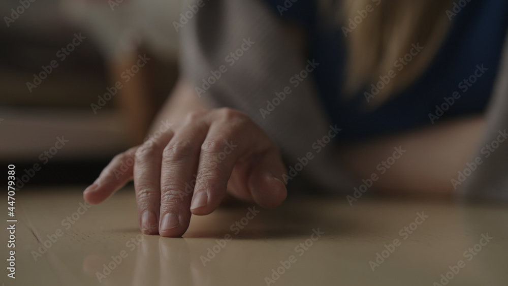 Woman sitting behind the table and finger tapping, waiting for something