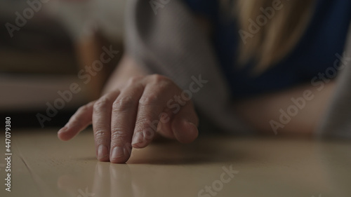 Woman sitting behind the table and finger tapping, waiting for something