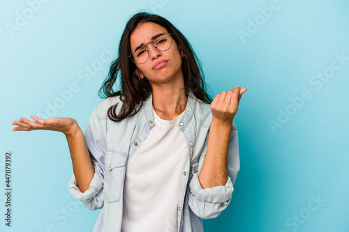 Young caucasian woman isolated on blue background showing that she has no money.