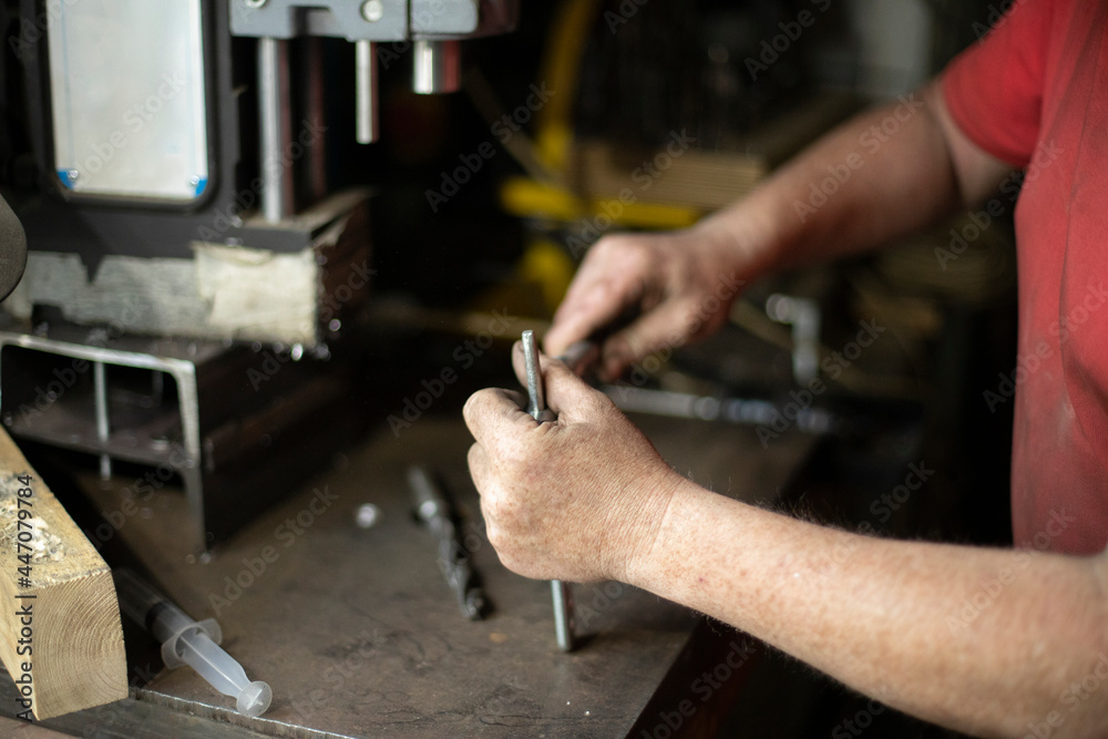 A man pulls out a drill. Installing a drill for a drill. Works in the garage. A man pulls out a drill. Installing a drill for a drill. Works in the garage.