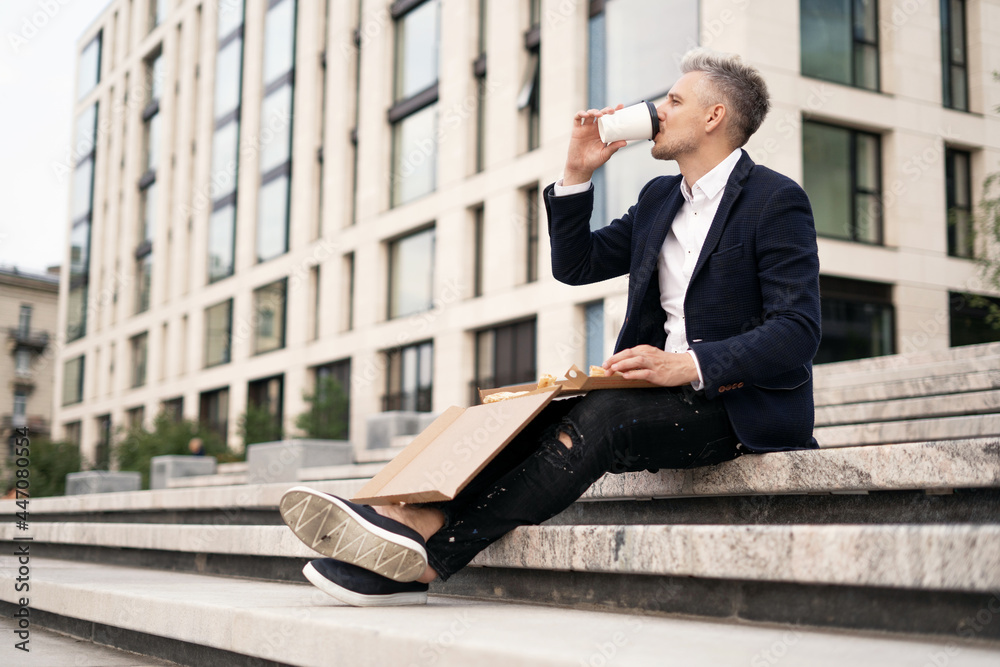 The lawyer takes a break and ordered pizza with delivery and Americano coffee. A business man is dressed in a stylish jacket. The manager is an adult of European appearance, a stylish gray-haired man. The lawyer takes a break and ordered pizza with delivery and Americano coffee. A business man is dressed in a stylish jacket. The manager is an adult of European appearance, a stylish gray-haired man.