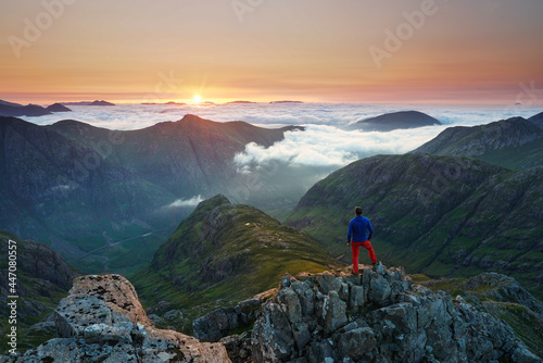 Unrecognizable Tourist taking in a sunrise view over the three sisters mountains, Glencoe, Highlands, Scotland. photo