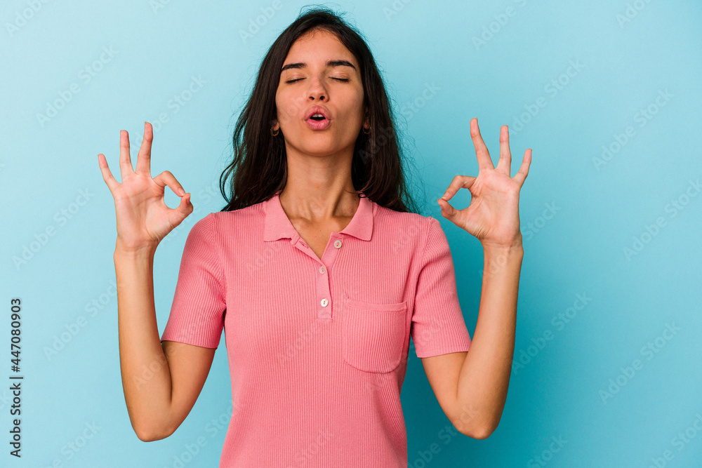 Young caucasian woman isolated on blue background relaxes after hard working day, she is performing yoga. Young caucasian woman isolated on blue background relaxes after hard working day, she is performing yoga.