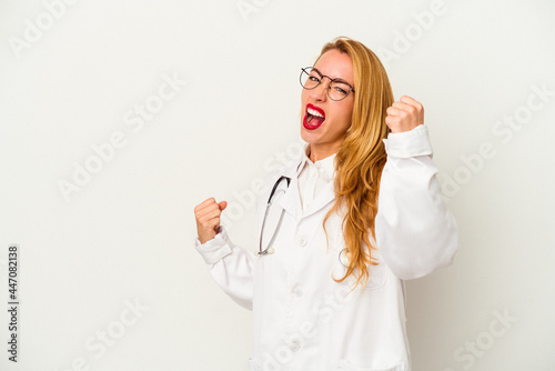 Caucasian doctor woman isolated on white background raising fist after a victory, winner concept.
