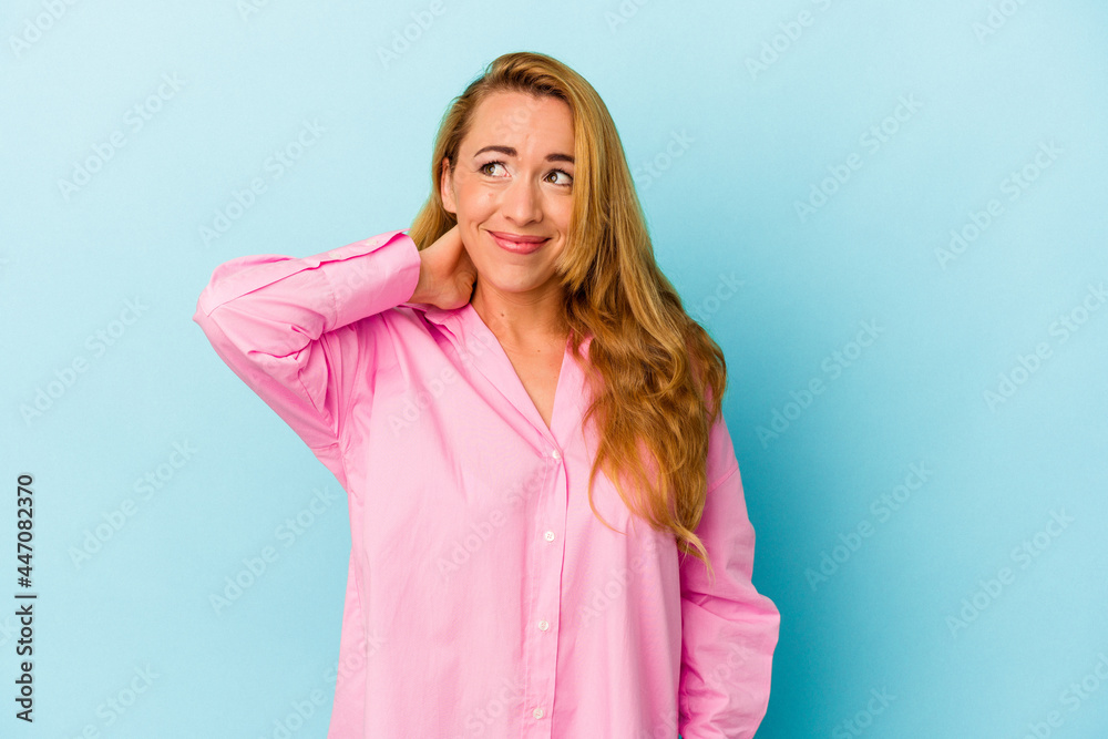 Caucasian woman isolated on blue background touching back of head, thinking and making a choice. Caucasian woman isolated on blue background touching back of head, thinking and making a choice.