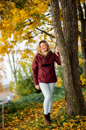 Playful young woman enjoying the fall yellow leaves in the autumn park. People  feelings  seasonal dating concept