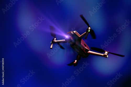 A flying drone. Airborne quadcopter. Also known as a drone or UAV, Unmanned Aerial Vehicle. Drone with camera on a colorful background with copy space.