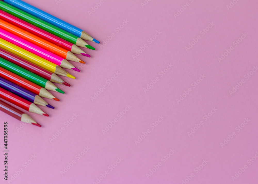 Colored bright pencils on a pink background with a copy of the space., Colored bright pencils on a pink background with a copy of the space.,