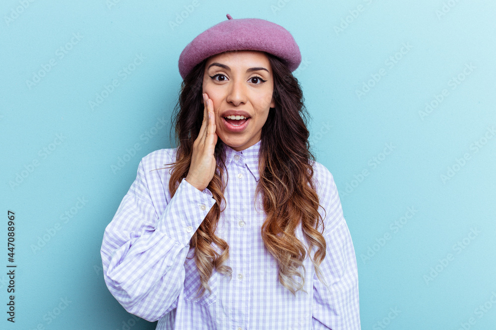 Young mexican woman isolated on blue background shouts loud, keeps eyes opened and hands tense. Young mexican woman isolated on blue background shouts loud, keeps eyes opened and hands tense.