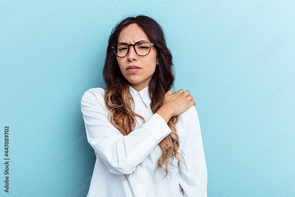 Young mexican woman isolated on blue background having a shoulder pain. Young mexican woman isolated on blue background having a shoulder pain.