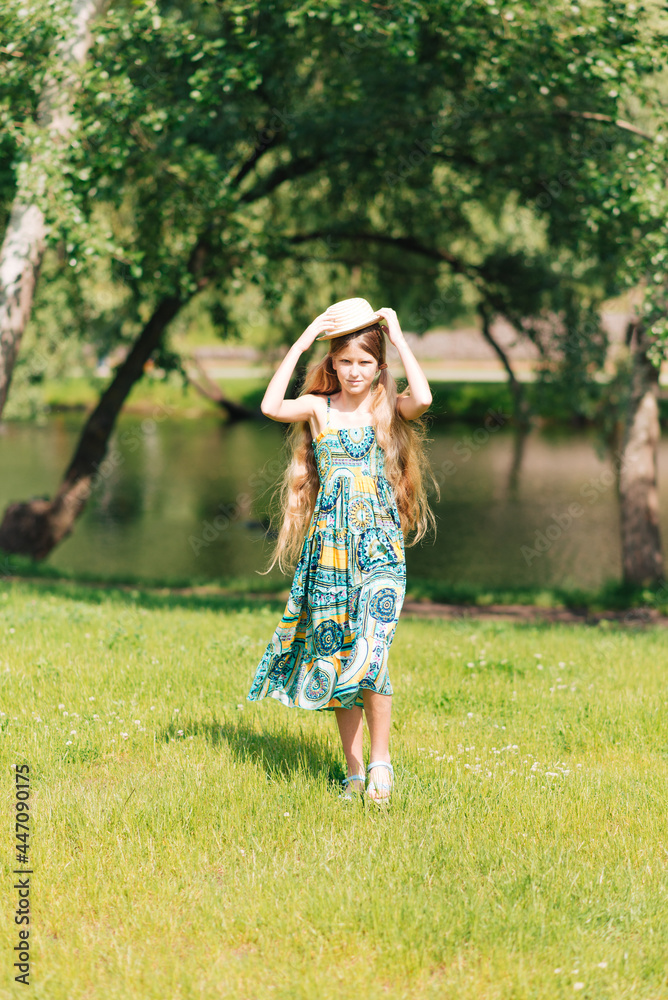 girl walks through the woods. girl with beautiful hair holding a straw hat in her hands girl walks through the woods. girl with beautiful hair holding a straw hat in her hands