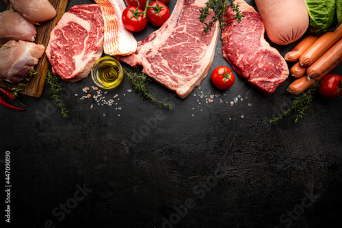 Variety of Fresh Raw meat and sausages on black background. Top view with space for your text