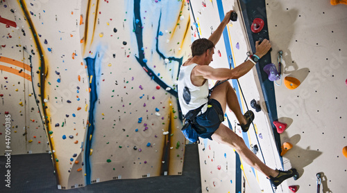 man climbing at indoor climbing wall in London photo